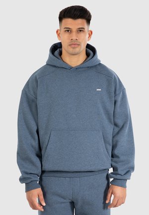 Gråblå hættetrøje lavet af blødt stof, der har en frontlomme og ribbede manchetter. Minimalistisk brandingdetalje på brystet.