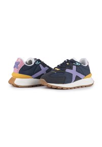 Sneakers blu navy e grigi con accenti viola, pannelli in rete e suola in gomma. Presentano una soletta bianca e dettagli colorati sul tallone.
