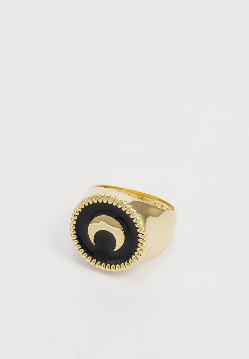 Anello d'oro con un centro in pietra nera rotonda, caratterizzato da un design a onde scolpito e un bordo testurizzato. Superficie liscia, forte contrasto.