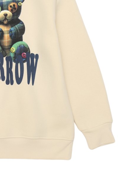Felpa color crema con grafica di un orso a quadri con bottoni colorati, maniche lunghe e polsini e orlo a coste.