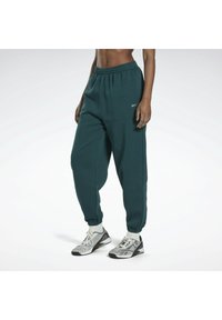 Småfetstilta teal sweatpants med avslappnad passform, elastisk midja och avsmalnade mudd. Har en diskret logga på vänster höft. Gjorda av mjukt tyg.