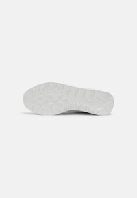 Weiße Sneaker-Sohle aus strukturiertem Gummi mit dreieckigen Profilen für Grip und einem geriffelten Rand. Sauberes, minimalistisches Design.