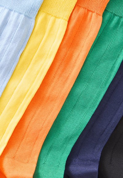 Six paires de chaussettes en tricot côtelé alignées côte à côte en bleu clair, jaune, orange, vert, bleu marine et noir.