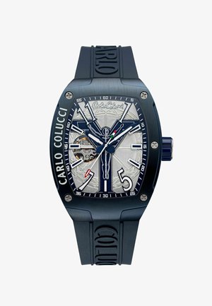 Men's watch with a blue rubber strap, silver textured dial, bold white hands, and a visible movement behind an open face.