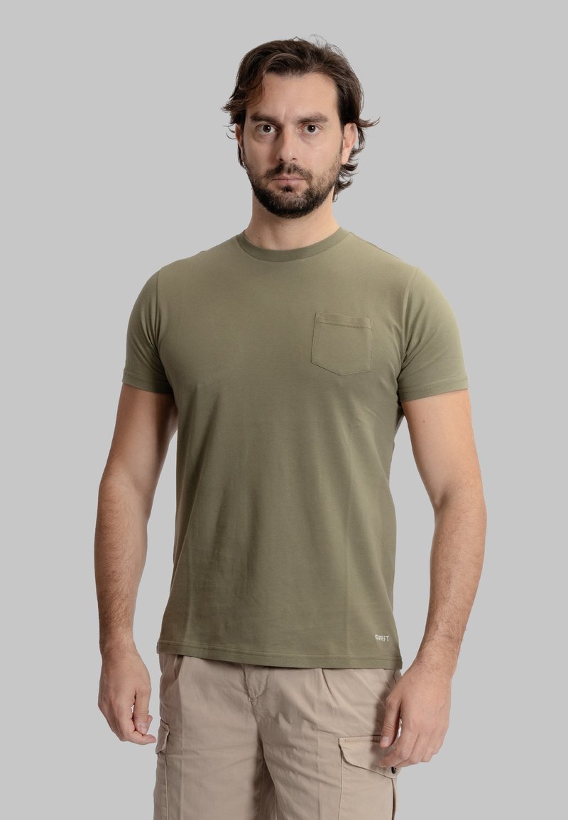 T-shirt verde oliva a maniche corte, realizzato in morbido cotone, con collo rotondo e una tasca sul petto. Design aderente con una texture liscia.
