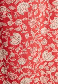 Roter Stoff mit einem weißen Blumenmuster, das verschiedene Blumenformen und Blattakzente zeigt, mit aufwendigen Details und Linienarbeiten.