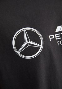 Czarny T-shirt z białym logo gwiazdy Mercedes-Benz oraz białym napisem "PETER". Miękka, gładka tkanina z klasycznym okrągłym dekoltem.