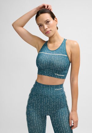Teal sportbeha en legging set met witte verticale lijnpatronen; gemaakt van een rekbare stof; racerback ontwerp; logo op de tailleband.