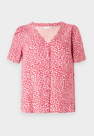Kurzärmliges Oberteil aus pinkem Stoff mit weißen Punkten, das einen V-Ausschnitt und eine Knopfleiste hat. Texturiertes, lässiges Design mit gerafftem Schulterdetail.