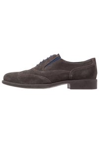 Chaussure habillée en daim gris foncé avec un bout arrondi, des accents de lacets bleus et des coutures contrastantes, montée sur une semelle noire lisse.