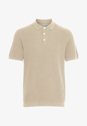 Vaaleanbeige lyhythihainen polo-paita, joka on valmistettu teksturoidusta kankaasta, jossa on uritettu muotoilu. Paidassa on kauluspäällinen ja kolme valkoista nappia napituksessa.