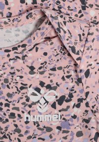 Tissu rose à motifs avec des éclaboussures noires et violettes. Présente le logo blanc "hummel". Encolure ronde et finition texturée.
