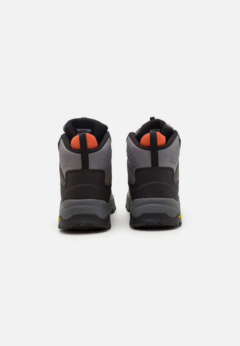 Szare i czarne buty trekkingowe z wysokim cholewką, z akcentami w kolorze pomarańczowym i teksturowanymi powierzchniami. W komplecie podeszwa Vibram i uchwyt do zakupu.