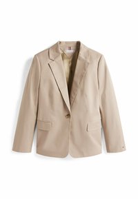 Blazer beige su misura con rever a scatto, due tasche frontali, chiusura con un bottone e una texture liscia. Interno foderato con una leggera lucentezza.