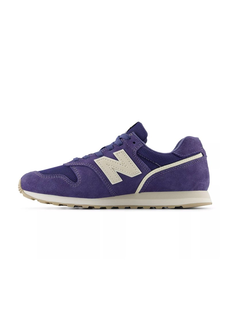 Baskets de sport en daim violet avec des accents beiges, design à lacets, col rembourré et semelle extérieure texturée pour une meilleure adhérence. Logo sur le côté visible.