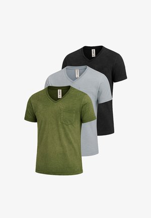 Olivegrünes V-Neck T-Shirt mit kurzen Ärmeln und Brusttasche, kombiniert mit hellblauen Slim-Fit-Jeans und beigen Slippern.