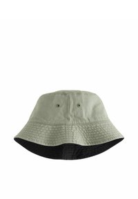 Een bucket hat van groene stof met een zwarte onderkant. Heeft een brede rand en twee ventilatiegaten aan de bovenkant voor ademend vermogen.