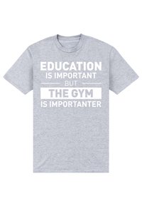 Camiseta de algodón gris con un audaz texto blanco: "LA EDUCACIÓN ES IMPORTANTE, PERO EL GIMNASIO ES MÁS IMPORTANTE" en varias tamaños de fuente. Manga corta.