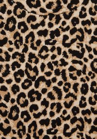 Tkanina s leopardím vzorom a ribbed textúrou. Prev dominance béžového pozadia s čiernymi leopardími škvrnami rôznych veľkostí.