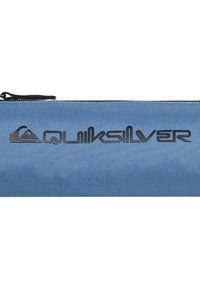 Blauwe stoffen etui met een gestructureerde afwerking en zwart 'Quiksilver' logo dat op de voorkant is geperst. Voorzien van een zwarte rits en trekhaak.
