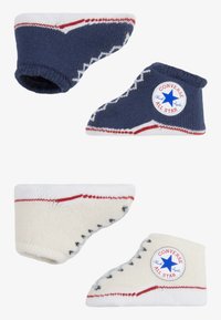 Babysockor i marinblått och vitt med Converse-logotyp, kontrasterande ränder och stickad textur. Designade för att likna klassiska höga sneakers.