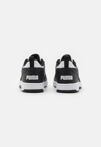 Black and white athletic shoes with a smooth synthetic upper, contrasting accents, and a thick white sole featuring the Puma logo on the heel.