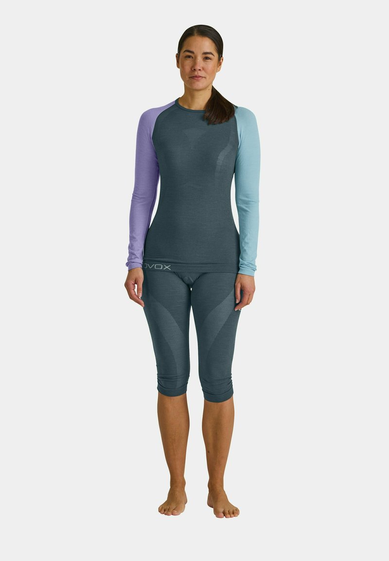 Two-piece activewear set in dark gray with purple and light blue long sleeves. The top features a fitted design and the bottoms have textured accents.