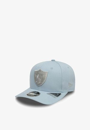 Jasnoniebieska czapka z emblematem srebrnej tarczy z przodu, z nachyloną daszkiem, regulowanym zapięciem snapback i teksturą z materiału.