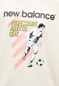 Mężczyzna grający w piłkę nożną w ruchu z piłką, tekst "new balance" i "professional athletic gear" na beżowym tle.