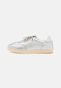 Silverfärgade metalliska låga sneakers med en slät yta, vita snören, beige sula och subtila sömnadsdetaljer på baksidan.