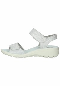 Sølv sandal med teksturerede stropper, justerbare velcro-lukninger, polstret sål og hvid kile-sål med et mønsterdesign.