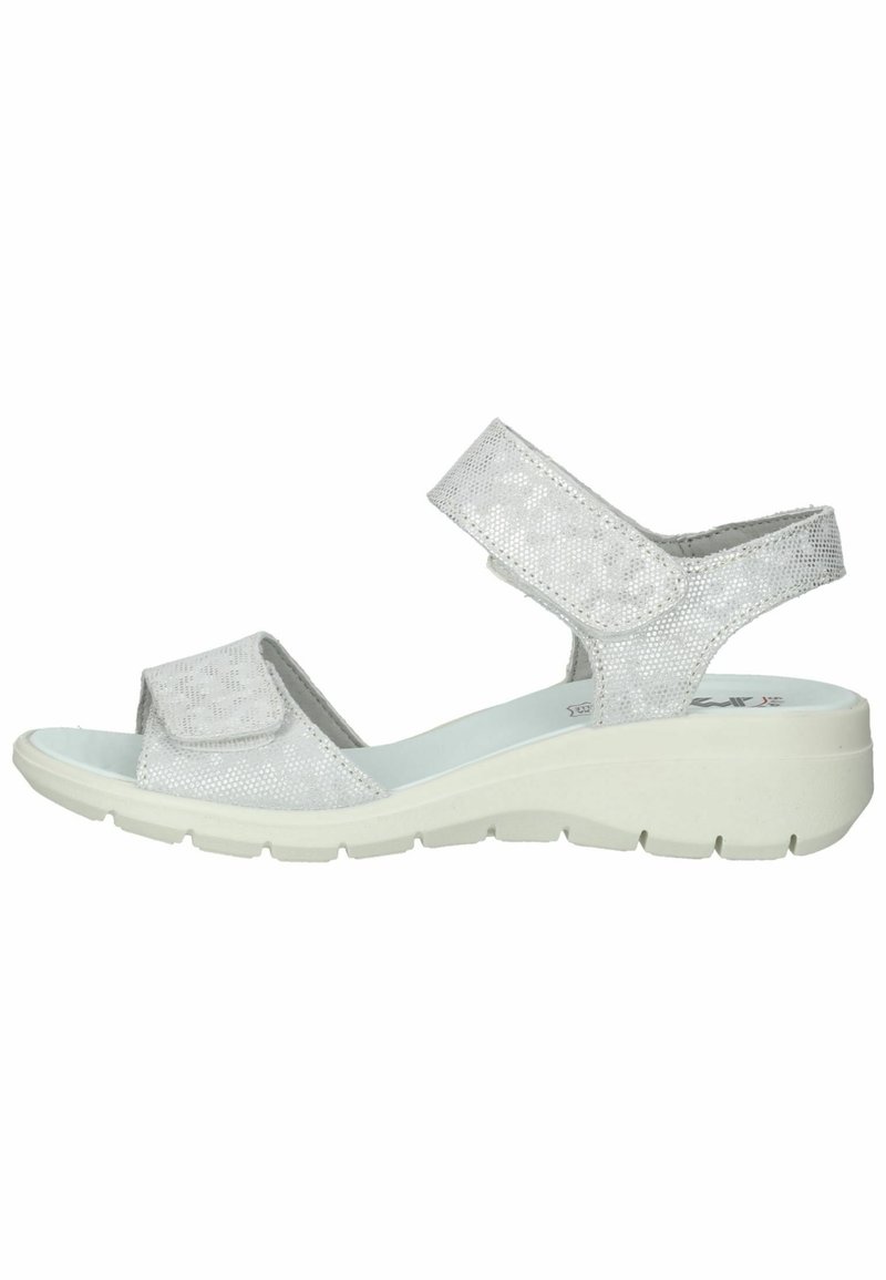 Sølv sandal med teksturerede stropper, justerbare velcro-lukninger, polstret sål og hvid kile-sål med et mønsterdesign.
