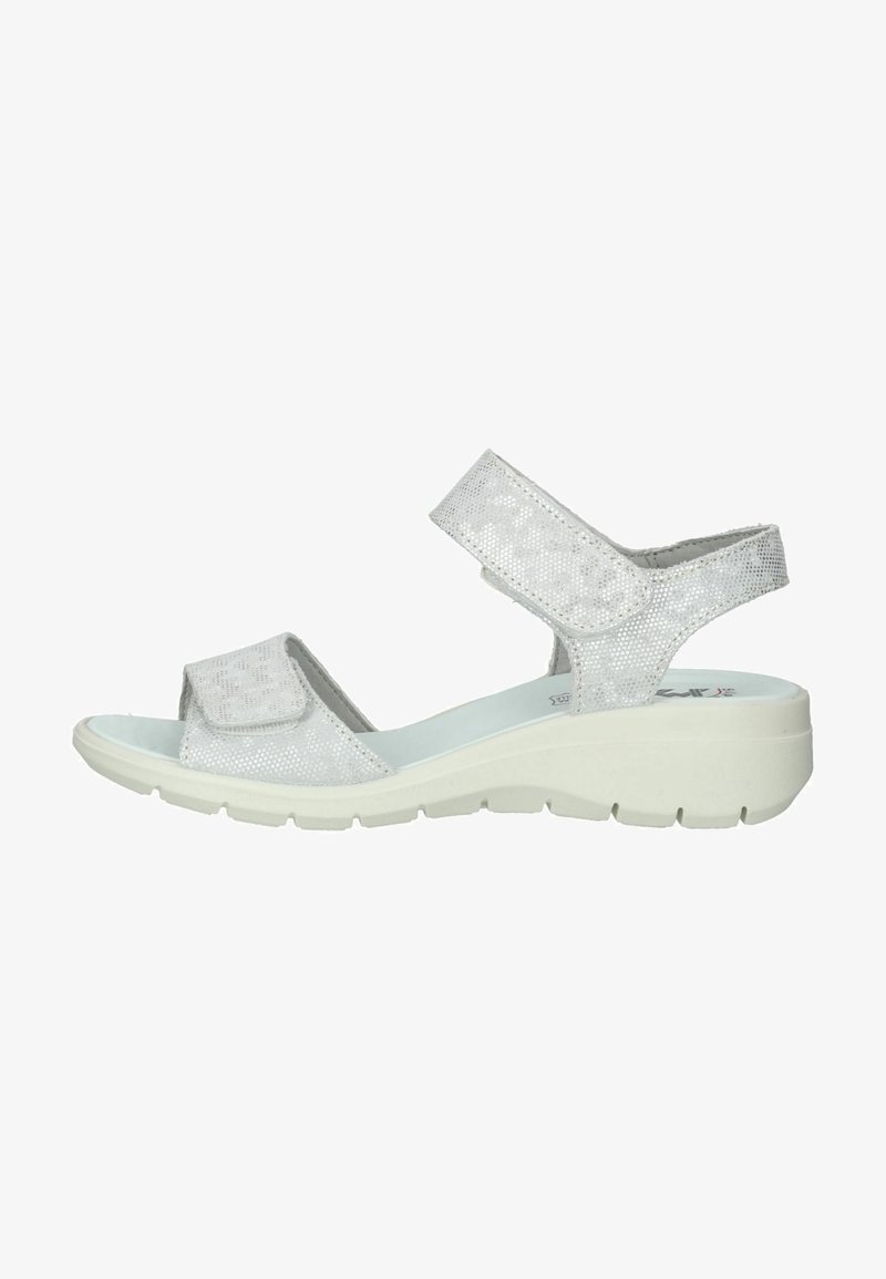Sølv sandal med teksturerede stropper, justerbare velcro-lukninger, polstret sål og hvid kile-sål med et mønsterdesign.