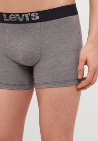 Grau cotton Boxershorts mit einem marineblauen Bund und "Levi's"-Logo. Der Stoff zeigt ein dezentes, strukturiertes Muster.