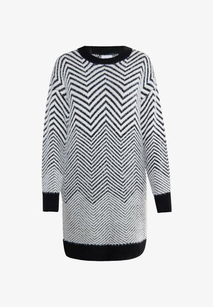 Kootud sviiter valge ja mustaga, millel on chevron muster. Pikkade varrukatega ja ümar kaelus musta sooniku serva ja mansettidega.