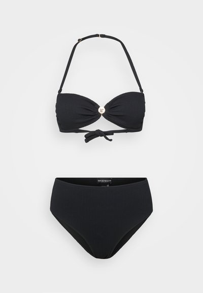 Svart bikini sett med ribbet tekstur, justerbare stropper og detaljer i gullfarge i midten av toppen. Høyt liv på bunn.