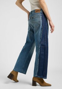 Vida jeans med vida ben som har en blandning av ljus och mörk blå denim, med en midjeband höjd och en Lee-logotyp på bakfickan.