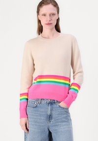 Beige genser laget av mykt materiale med rund hals. Har horisontale striper i rosa, blå, grønn og gul ved kanten og mansjettene.