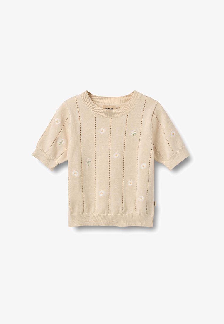 Beige korte mouw gebreide trui met kleine witte madeliefjesborduur en verticale opengebreide strepen.