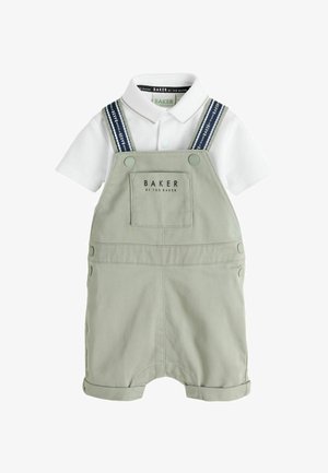 Weißes Poloshirt mit kurzen Ärmeln, kombiniert mit hellgrauer Latzhose mit gebrandeten marineblauen Trägern und einer Fronttasche mit "Baker by Ted Baker"-Logo.
