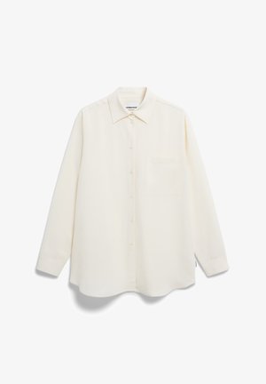 Chemise boutonnée couleur crème en tissu léger. Présente un col classique, des manches longues et une poche poitrinée unique. Texture lisse.