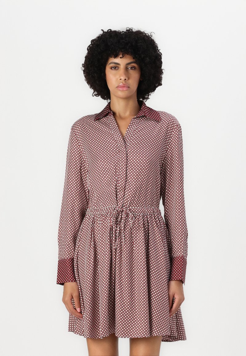 Rochie cu model roșu și alb, cu guler, mâneci lungi și talie cu șnur ajustabil, având un corset ajustat și fustă evazată.