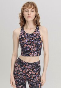 Floral crop top with a black base, featuring vibrant orange and purple floral patterns. Made of stretchable fabric, designed for comfort.