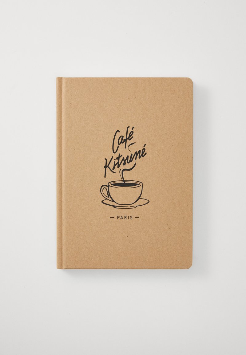 Brun innbundet notatbok med en svart konturillustrasjon av en kaffekopp og teksten "Café Kitsuné Paris" på omslaget.
