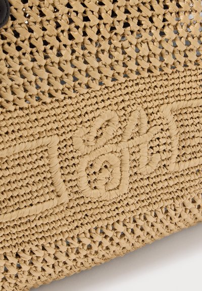 Εγγύς πλάνο υλικού από μπεζ πλεγμένο άχυρο που διαθέτει ανάγλυφο πλεγμένο σχέδιο σχηματίζοντας μια υφή με λέξη.