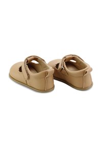 Zapatos de niño de cuero color beige con punta redonda, cierre de tira, recortes decorativos y suela de goma suave.