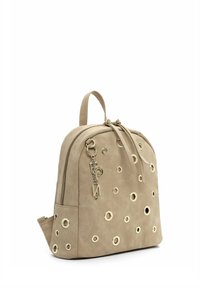 Zaino in suede beige con dettagli in occhiello dorato, chiusura con cerniera e doppi spallacci. Presenta un portachiavi decorativo attaccato alla cerniera.