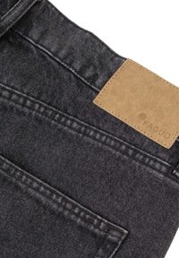 Tascone posteriore e vita di jeans in denim neri con una toppa rettangolare in pelle marrone cucita sulla vita.