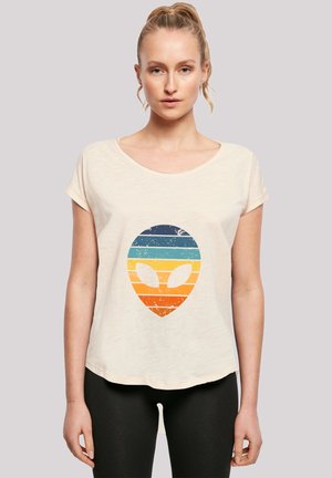 Cream-colored t-shirt with a relaxed fit. Features a distressed graphic of an alien head with horizontal stripes in blue, orange, and yellow.