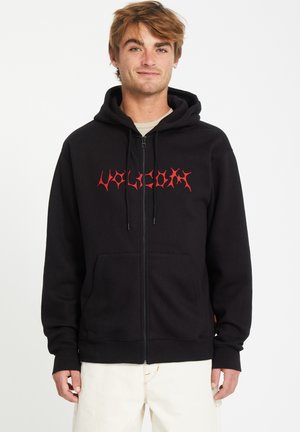 Black zip-up hoodie with a red stylized "Volcom" logo. Features a front pocket, drawstring hood, and ribbed cuffs and hem.